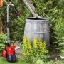 Einhell Regenfasspumpe GC-SP 4042 RB mit Kabel vor Regentonne im Garten.