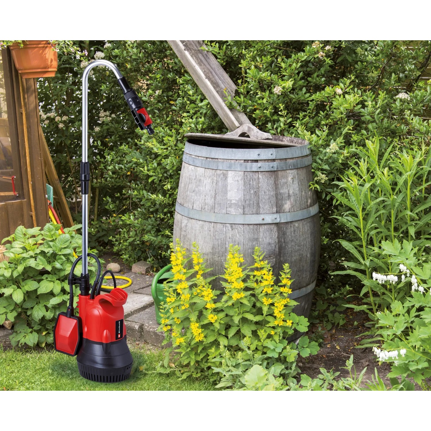 Einhell Regenfasspumpe GC-SP 4042 RB mit Kabel vor Regentonne im Garten.