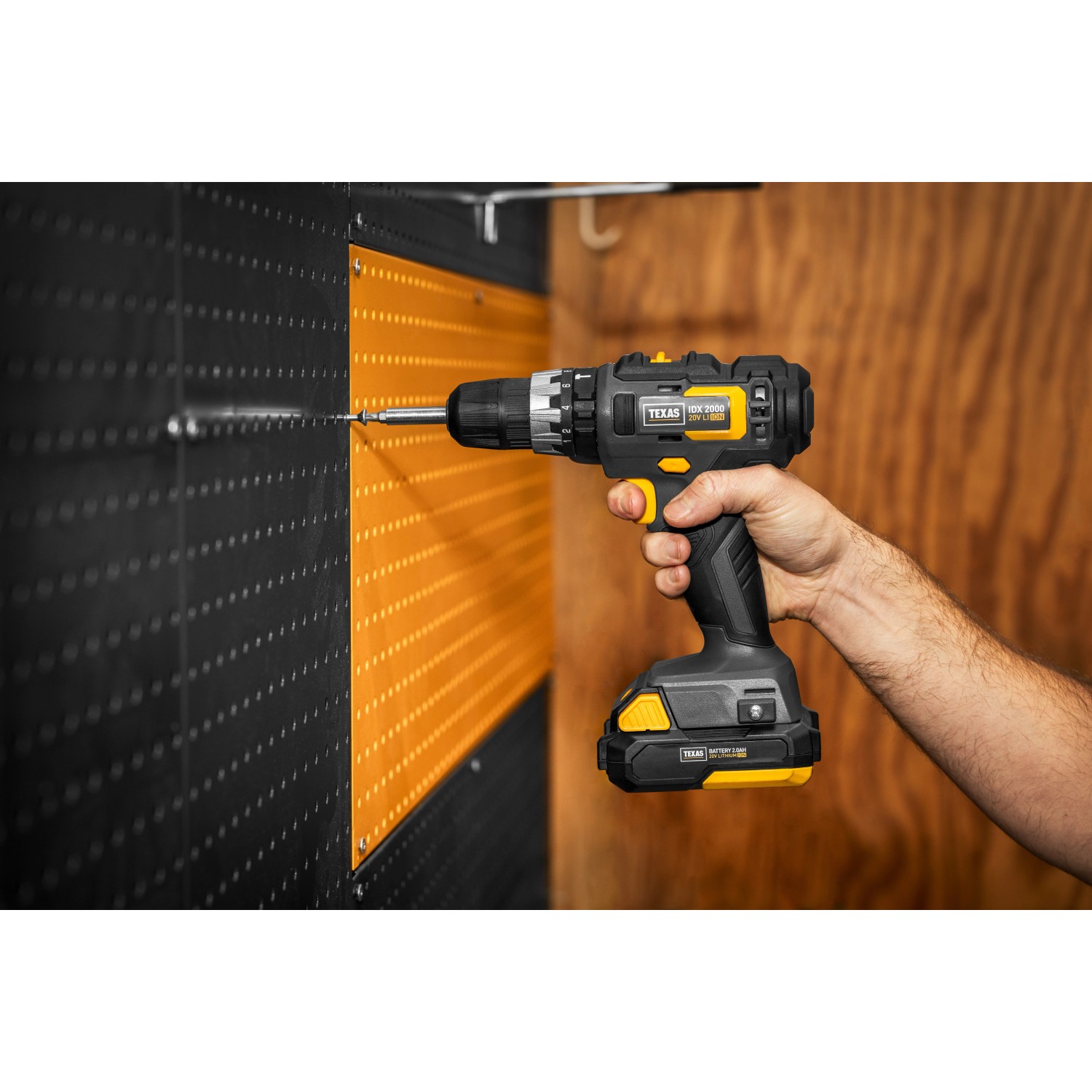 Texas 20V Schlagbohrmaschine IDX2000 beim Bohren in eine Wand. Akkuschrauber in Schwarz und Gelb.