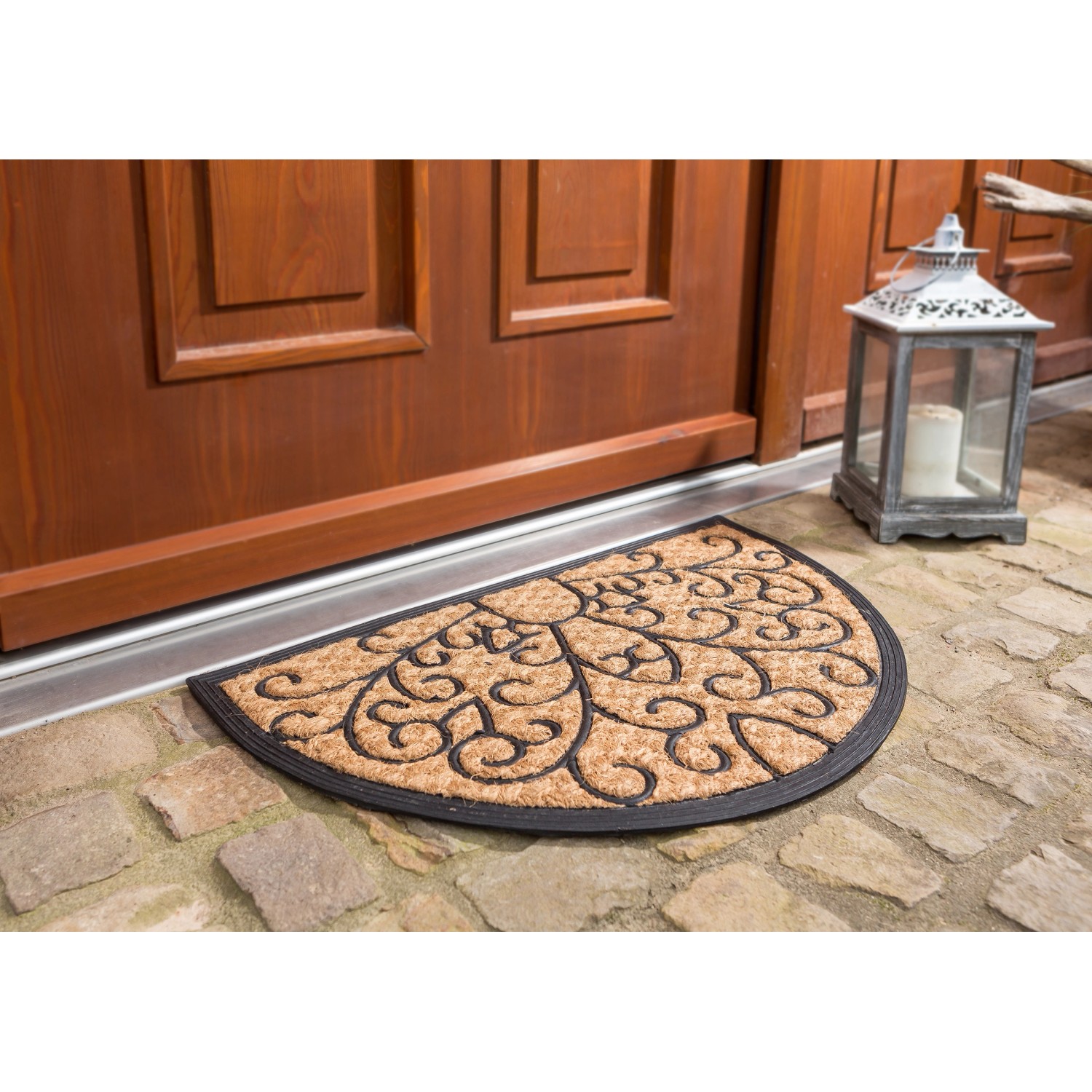 Halbrunde Fußmatte Coco Deluxe Light, 45x75 cm, mit Reliefmuster vor einer Haustür.