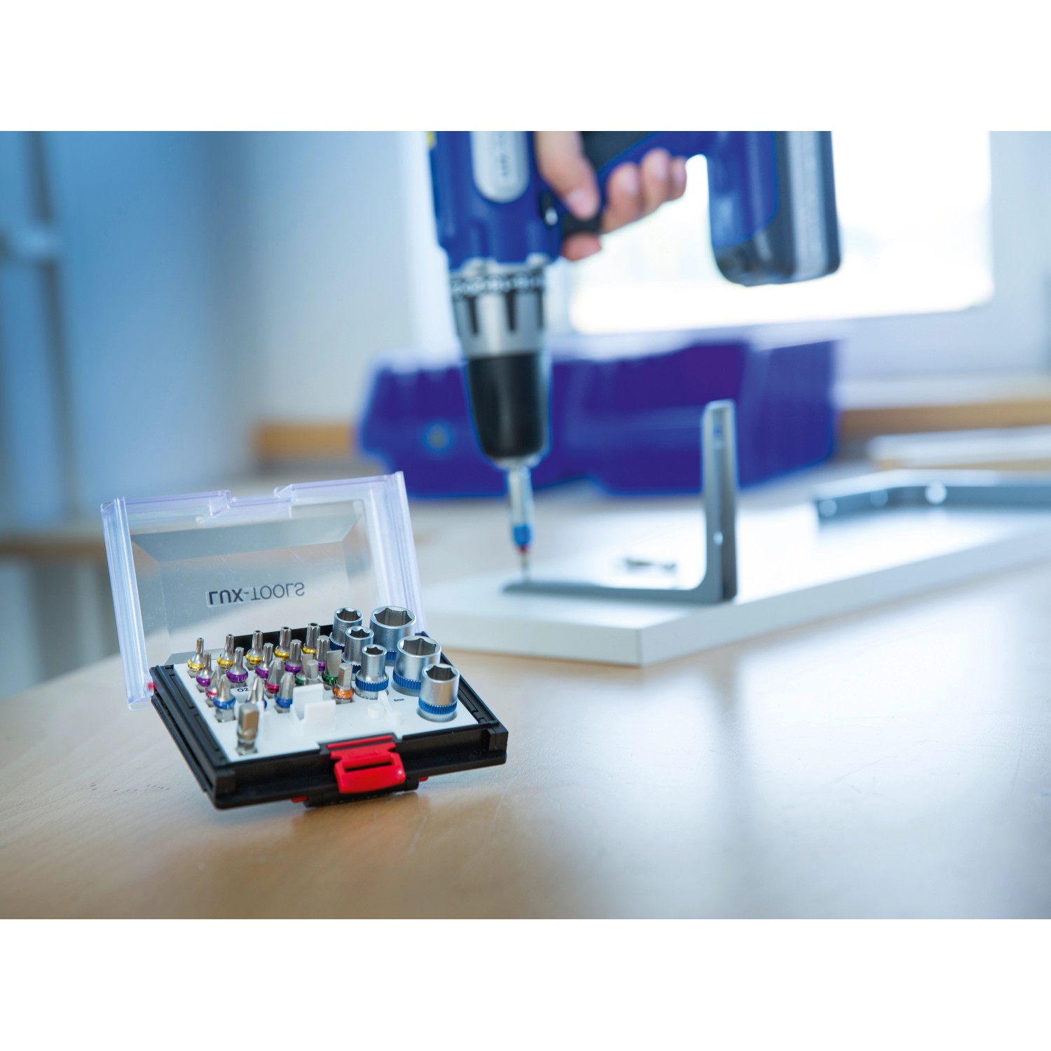 LUX Bit- und Steckschlüsselsatz (28-teilig) mit Farbsortierung in Kunststoffbox, im Einsatz mit Akkuschrauber.