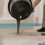 Mapei Bodenausgleichsmasse wird aus Eimer gegossen. Ausgleichsmassen für den Innen- und Außenbereich.