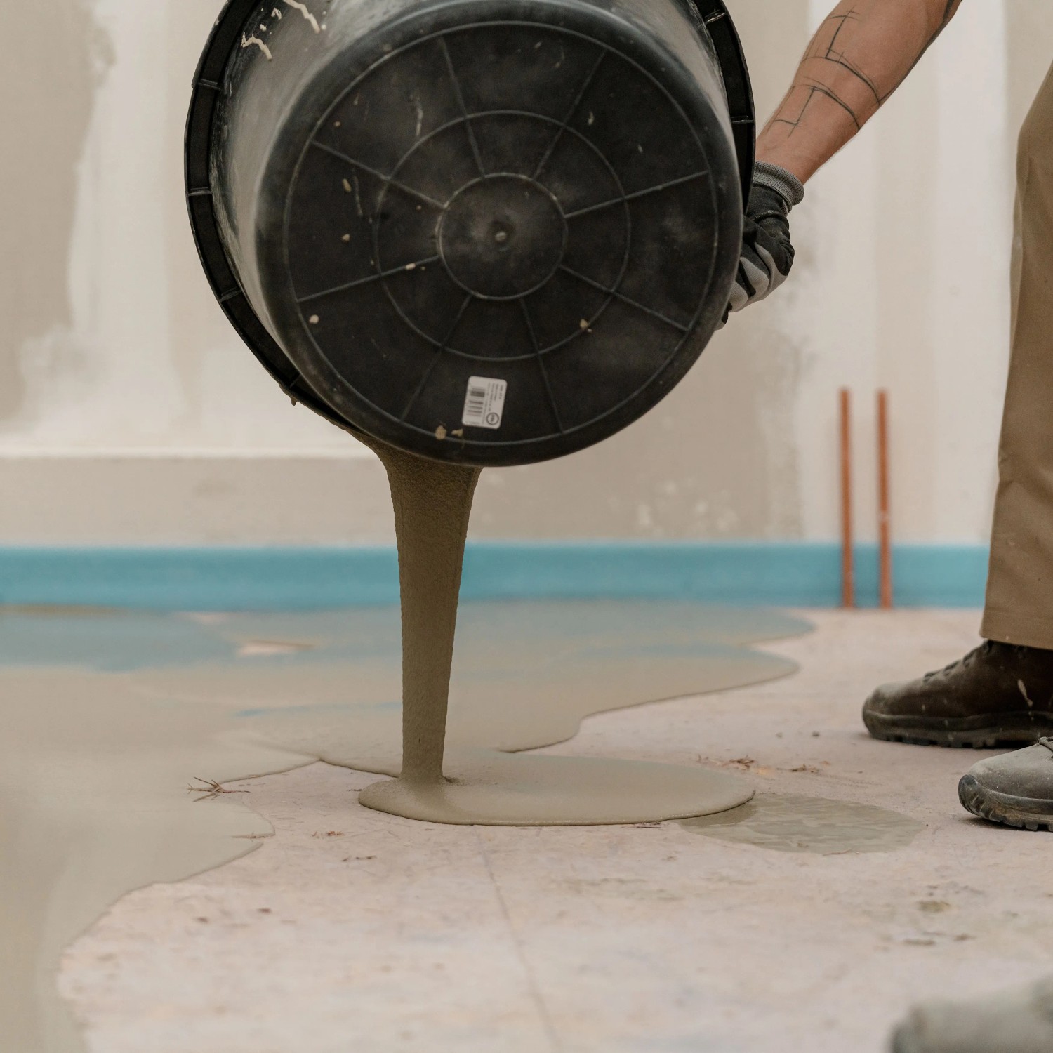Mapei Bodenausgleichsmasse wird aus Eimer gegossen. Ausgleichsmassen für den Innen- und Außenbereich.