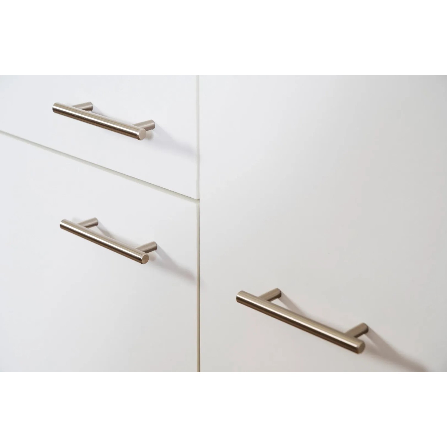 Detailaufnahme: Weiße Küchenzeile mit Edelstahlgriffen und Eiche Sägerau Dekor.