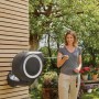 Gardena Wand-Schlauchbox RollUp S mit 15m Schlauch im Einsatz, Frau hält Schlauch in der Hand.
