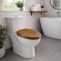 Sinobath WC-Sitz Oval in Pinienholzoptik mit Absenkautomatik auf weißem WC in modernem Bad.