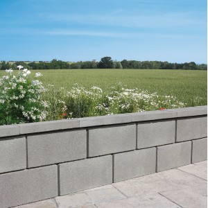 Häusler Abdeckplatte Granitgrau, 50x25x6 cm, auf einer Mauer. Sichtbeton mit Wassernase.