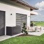Dunkelgraue Biohort Loungebox 160 auf Terrasse neben Haus. Universalbox für Sitzkissen und Gartenzubehör.