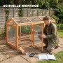 Mann montiert PawHut Hühnergehege aus Tannenholz mit Drahtgeflecht im Garten. Schneller Aufbau des Freilaufgeheges.