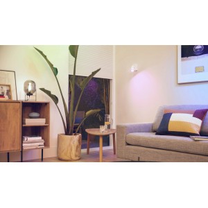 Philips Smart LED GU10 Reflektor in Wohnraum-Szene mit farbiger Beleuchtung.