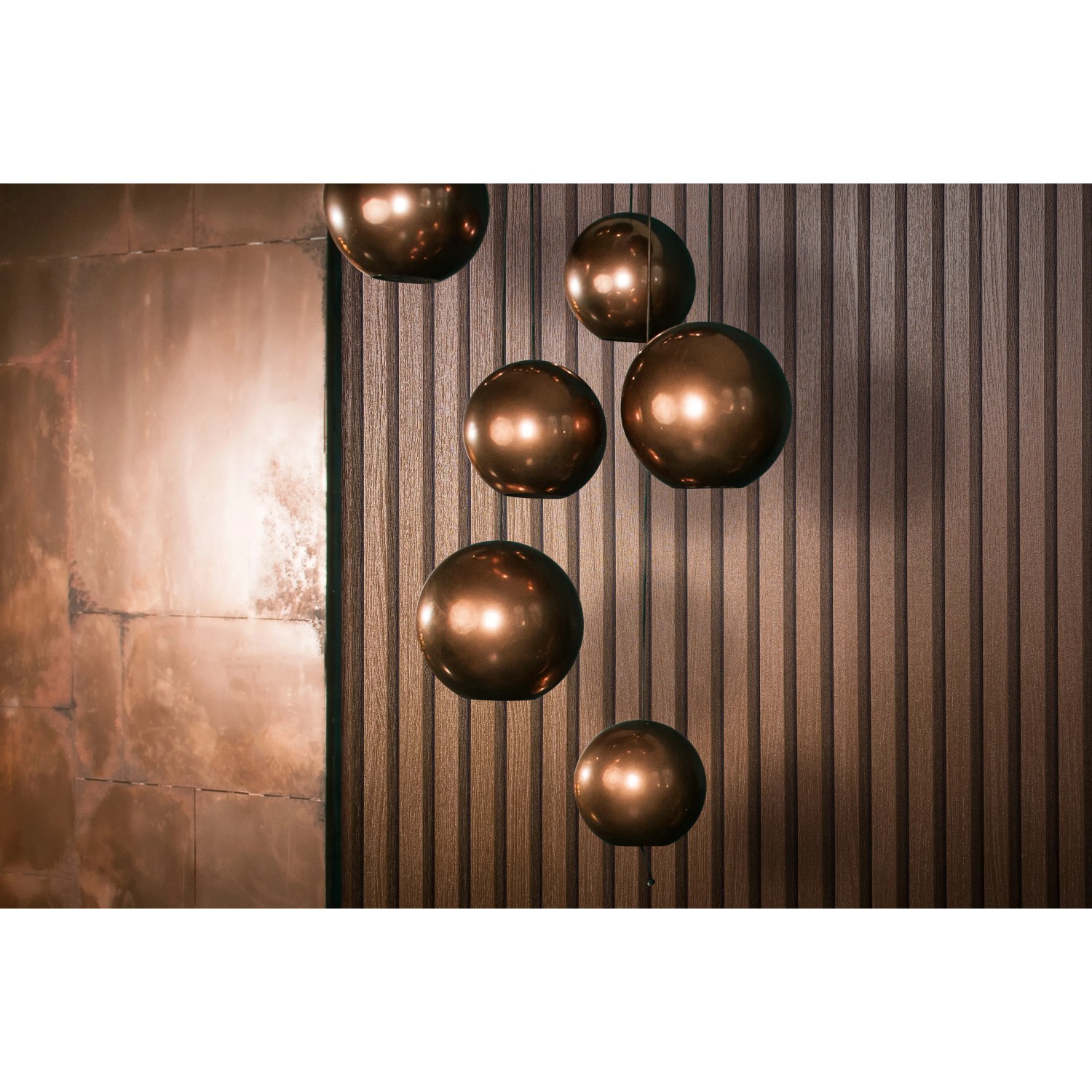 Marburg Vliestapete Akustikpaneel-Muster in Kupfer-Metalloptik an der Wand.