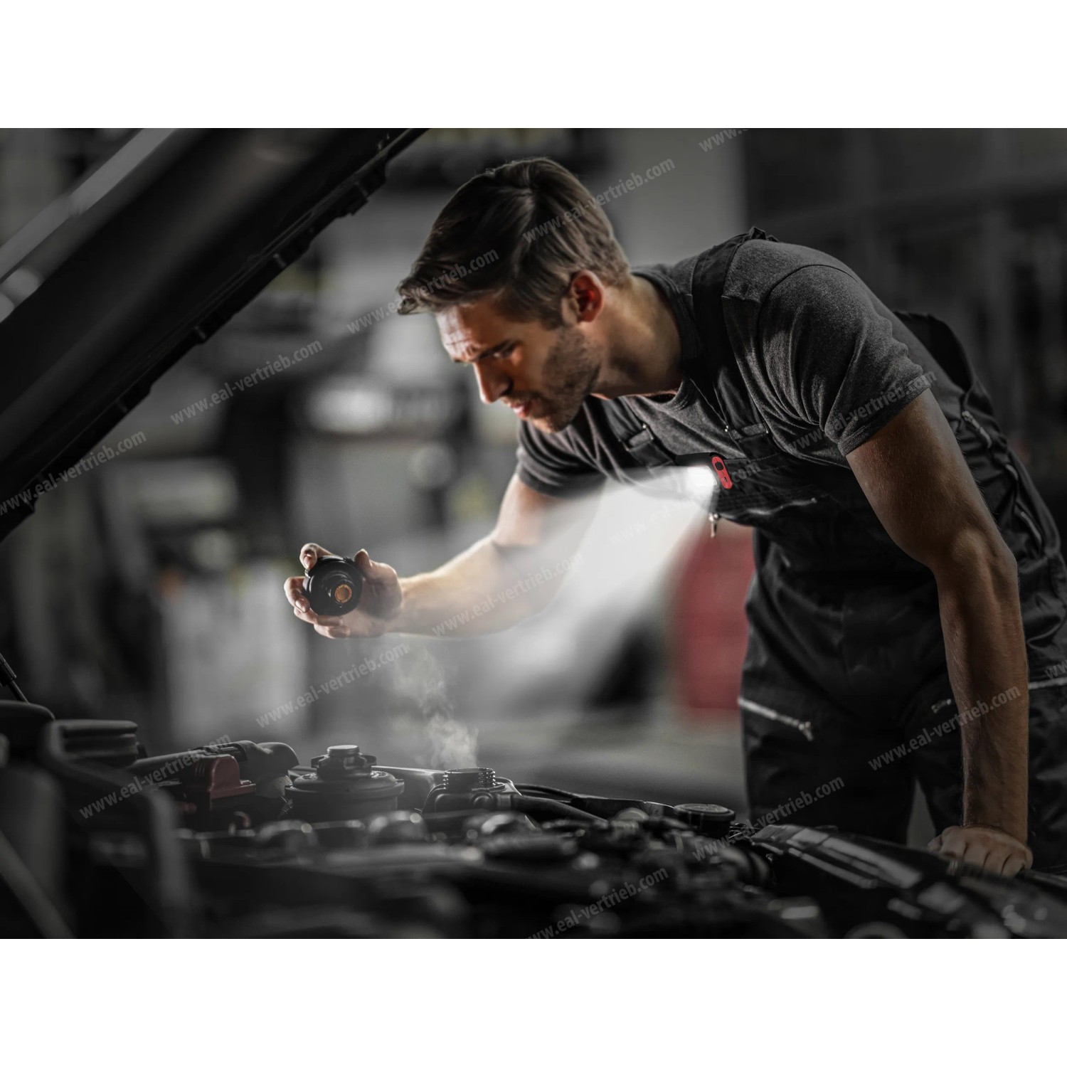 Mann repariert Auto mit APA LED Magnet Licht, befestigt an der Kleidung.