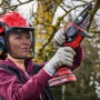 Frau schneidet Ast mit Einhell Akku-Kettensäge GE-PS 18/15 Li BL Kit. Inkl. Akku und Ladegerät.