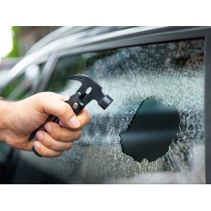 Hand mit LUX Multi-Tool Hammer Messer schlägt Autoscheibe ein.