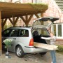 Frau belädt Auto mit Holz, gesichert mit LUX Stretchfolie. Ideal für Transport & Umzug.