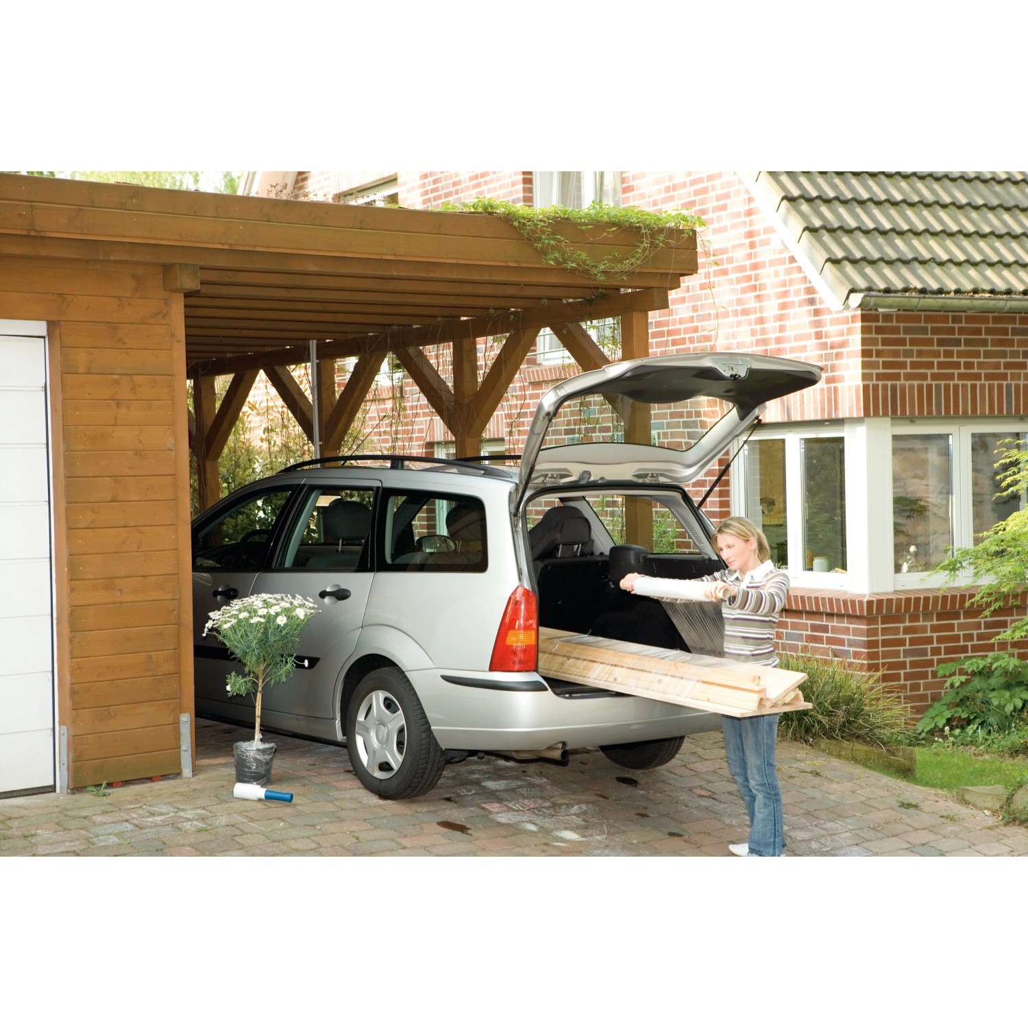 Frau belädt Auto mit Holz, gesichert mit LUX Stretchfolie. Ideal für Transport & Umzug.