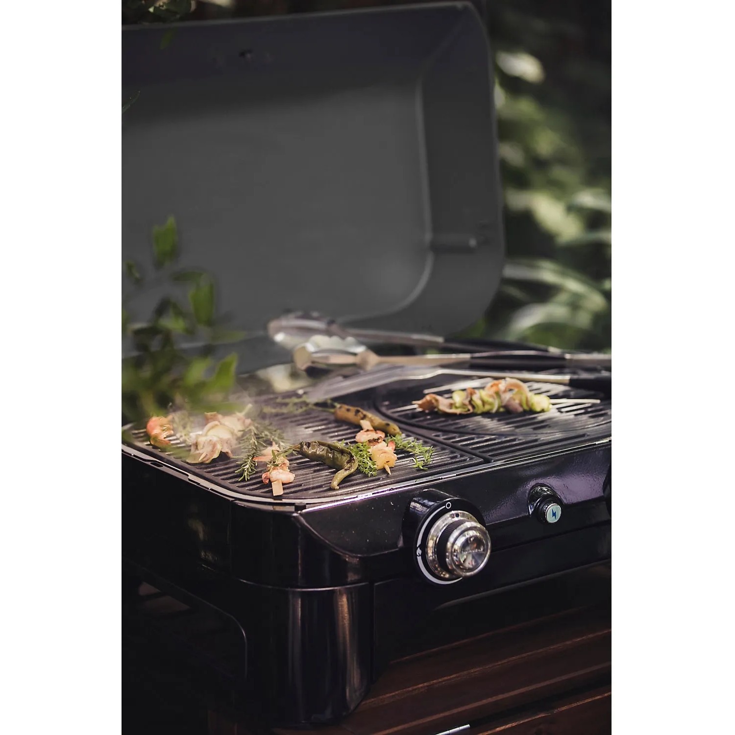 Campingaz Gas-Tischgrill Attitude 2100 LX beim Grillen von Gemüse und Fleisch.