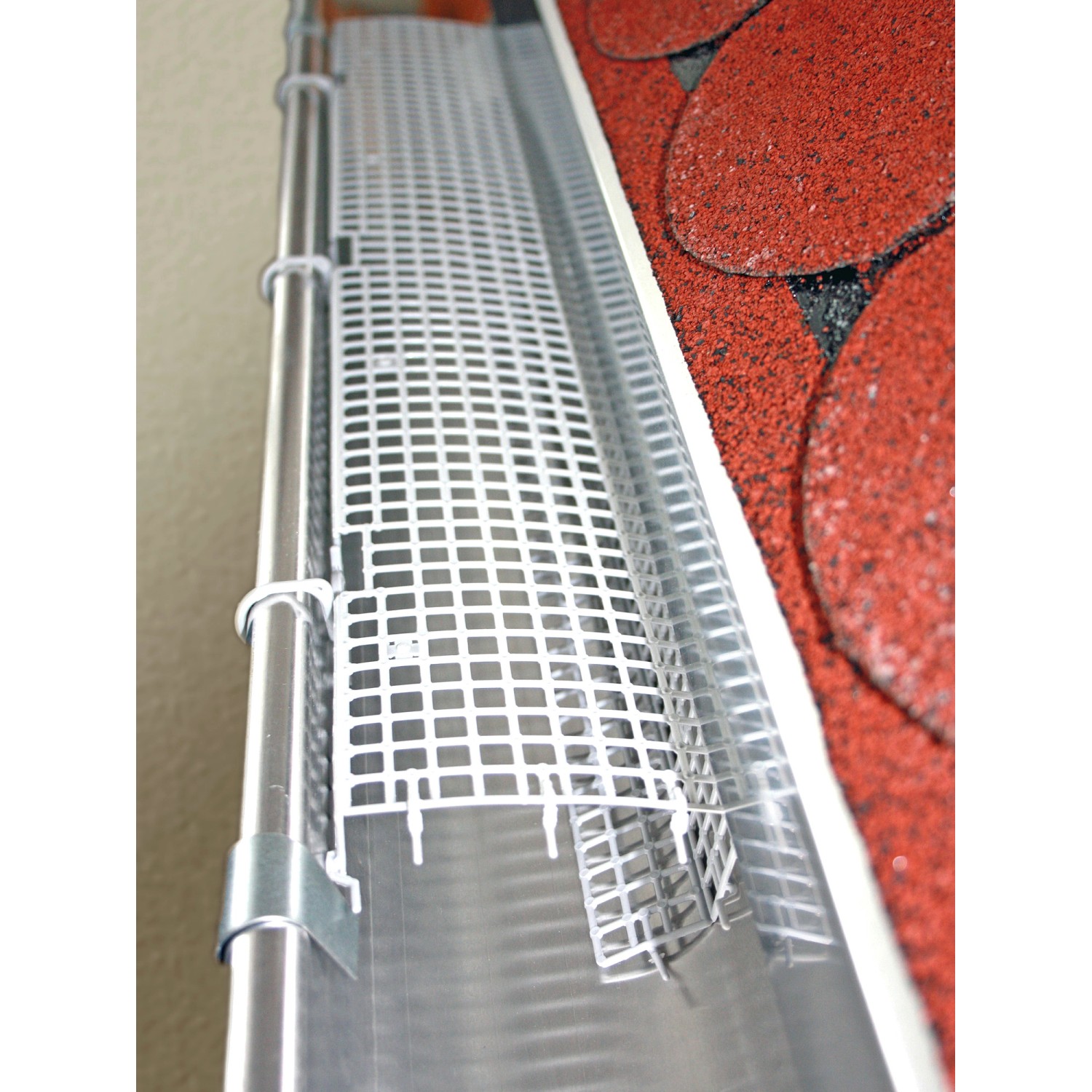 Grauer Sarei Laubstopp aus Polypropylen für eine Dachrinne.