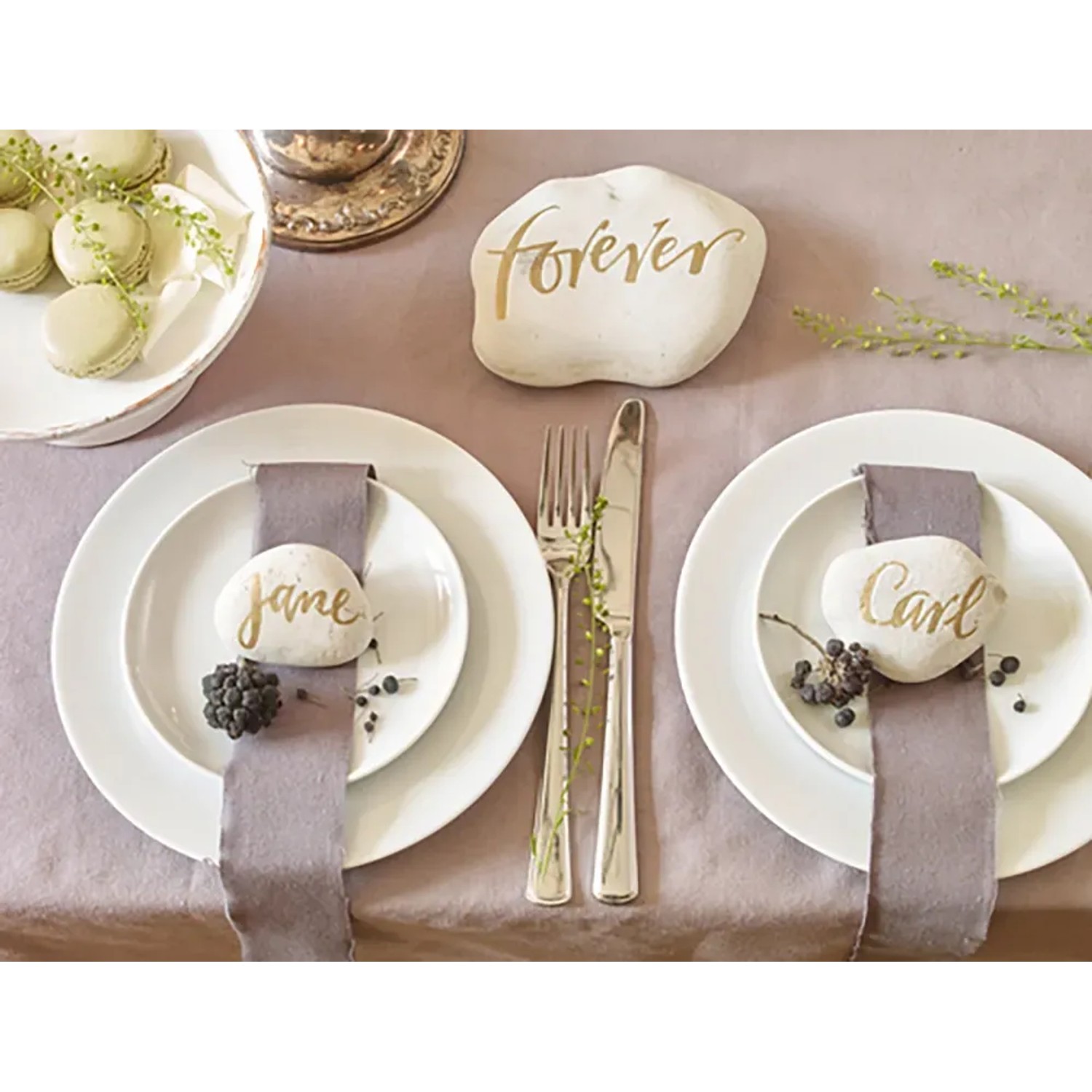 Tischdeko mit goldenen Schriftzügen auf Steinen, erstellt mit Edding Paintmarker.