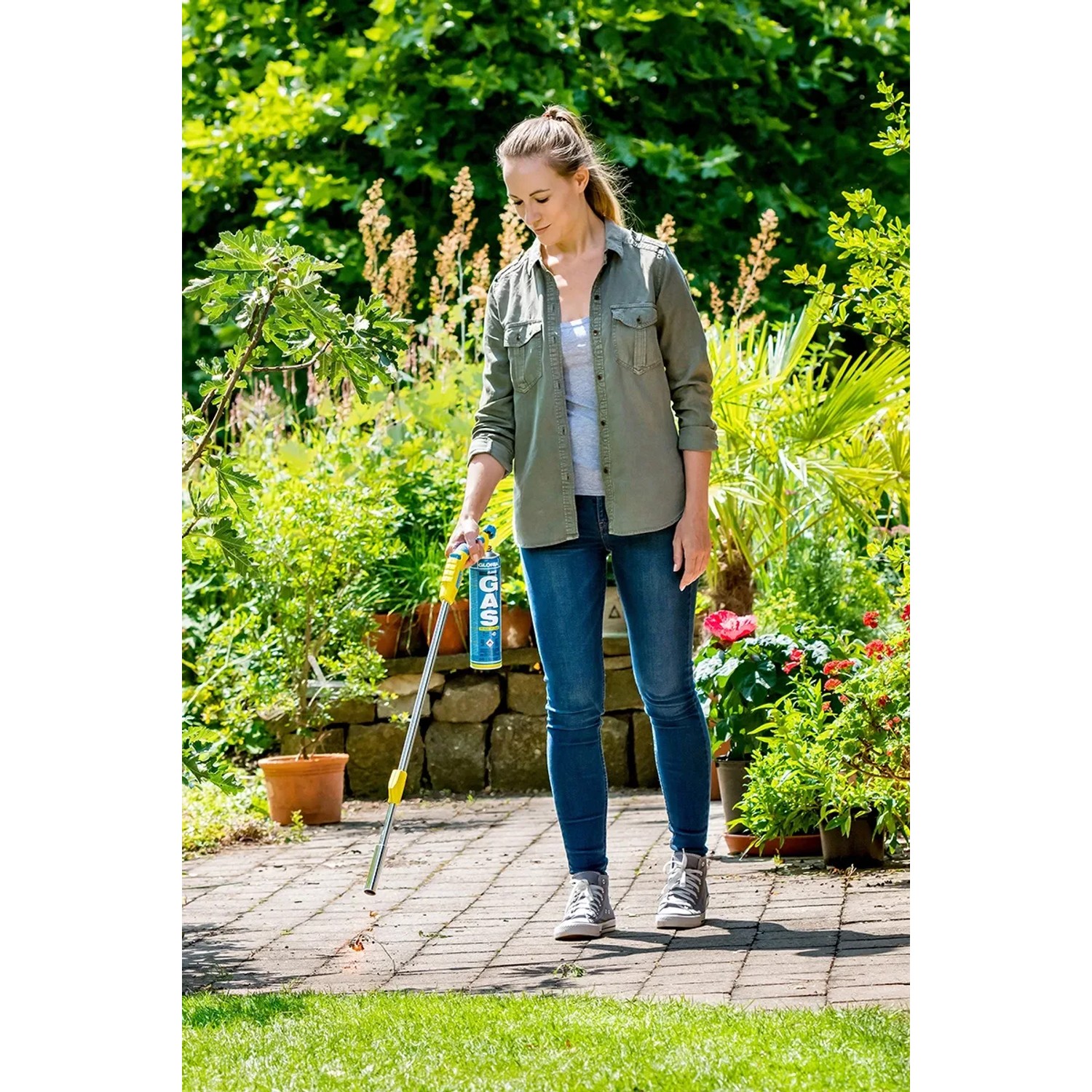 Frau benutzt Gloria Thermoflamm bio Comfort Plus Unkrautbrenner im Garten.