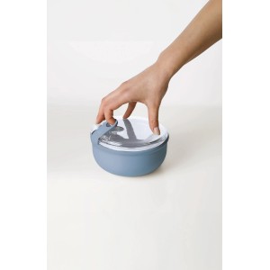 Runde, blaue Rotho Frischhaltedose Ela (0,75 l) mit transparentem Deckel wird von Hand verschlossen.