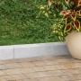 Grauer Rasenkantenstein (5x30x100 cm) zwischen Rasen und Pflaster, neben einem Topf mit Pflanze.
