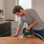 Mann sägt Holz mit Bosch Akku-Stichsäge UniversalSaw 18V-100. Stichsäge mit Staubabsaugung.
