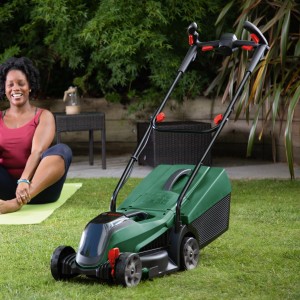 Bosch CityMower 18V-32 Akku-Rasenmäher mit Akku und Ladegerät im Garten.