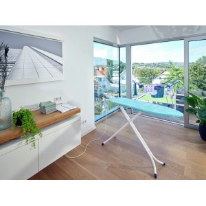 Leifheit Bügeltisch AirBoard Compact M Plus mit blauem Bezug und Bügeleisenablage im Raum.