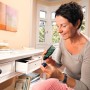 Frau bastelt mit Bosch Akku-Heißklebepistole GluePen an Tisch mit offener Schublade.