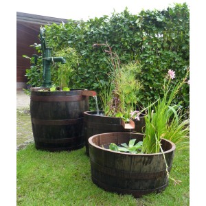 3-teiliges Wasserornament aus originalen Whiskyfässern mit Schwengelpumpe im Garten.
