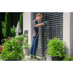 Mann reinigt Jalousien mit Gardena Cleansystem Jalousienbürste mit Wasseranschluss.
