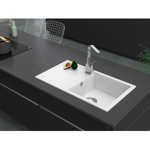 Weiße Miló Einbauspüle Blissano aus Granitverbundstoff mit Abtropffläche und Armatur auf dunkler Arbeitsplatte.