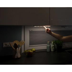 Weiße Müller-Licht LED Unterbauleuchte Mobina 15 in Küche mit Hand beim Einschalten.