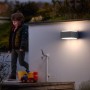 Moderne Philips myGarden Außenwandleuchte Hedgehog aus Edelstahl an Hauswand mit Kind und Spielzeugauto.