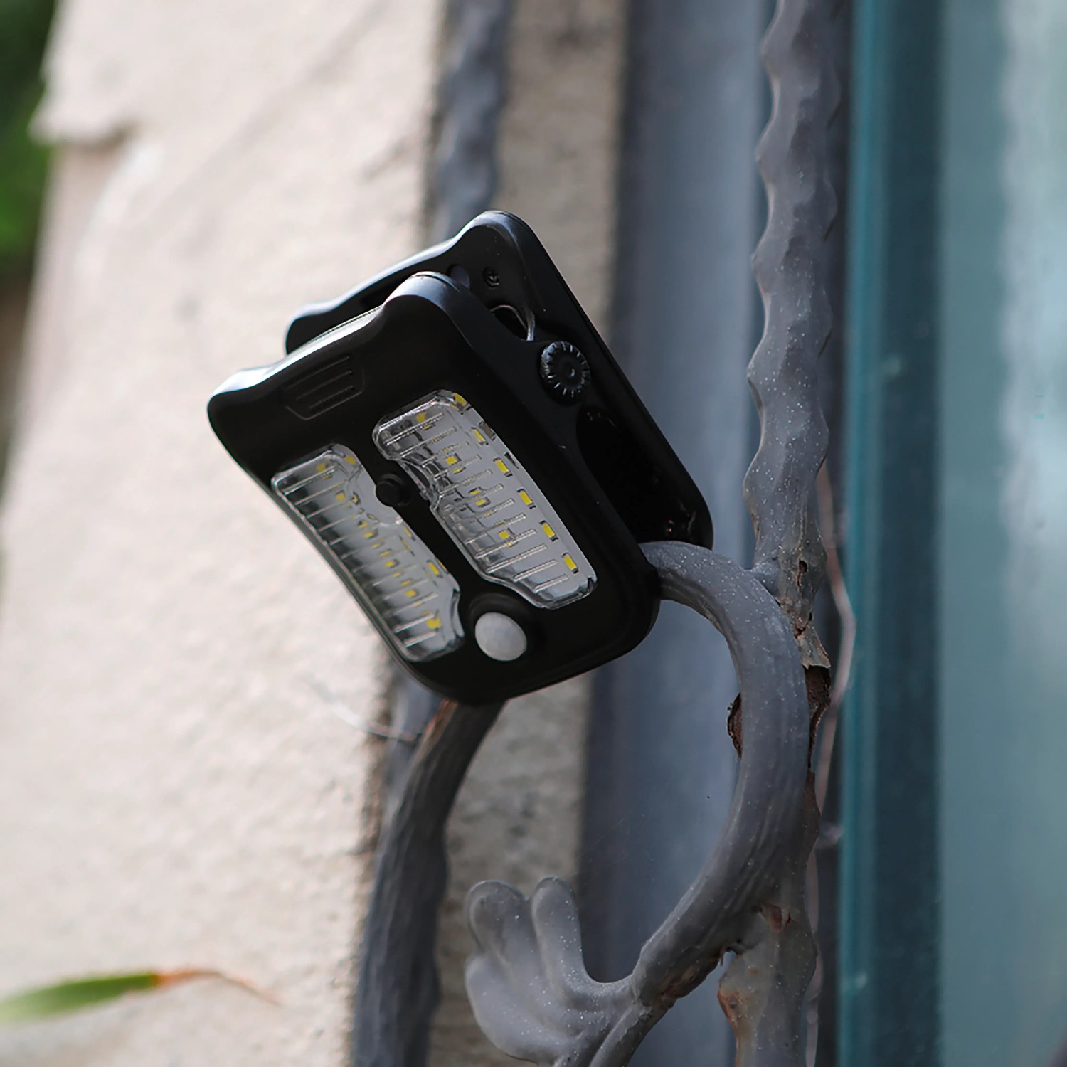 Schwarze Solar LED Gartenleuchte mit Clip-on an einem Metallgeländer befestigt.
