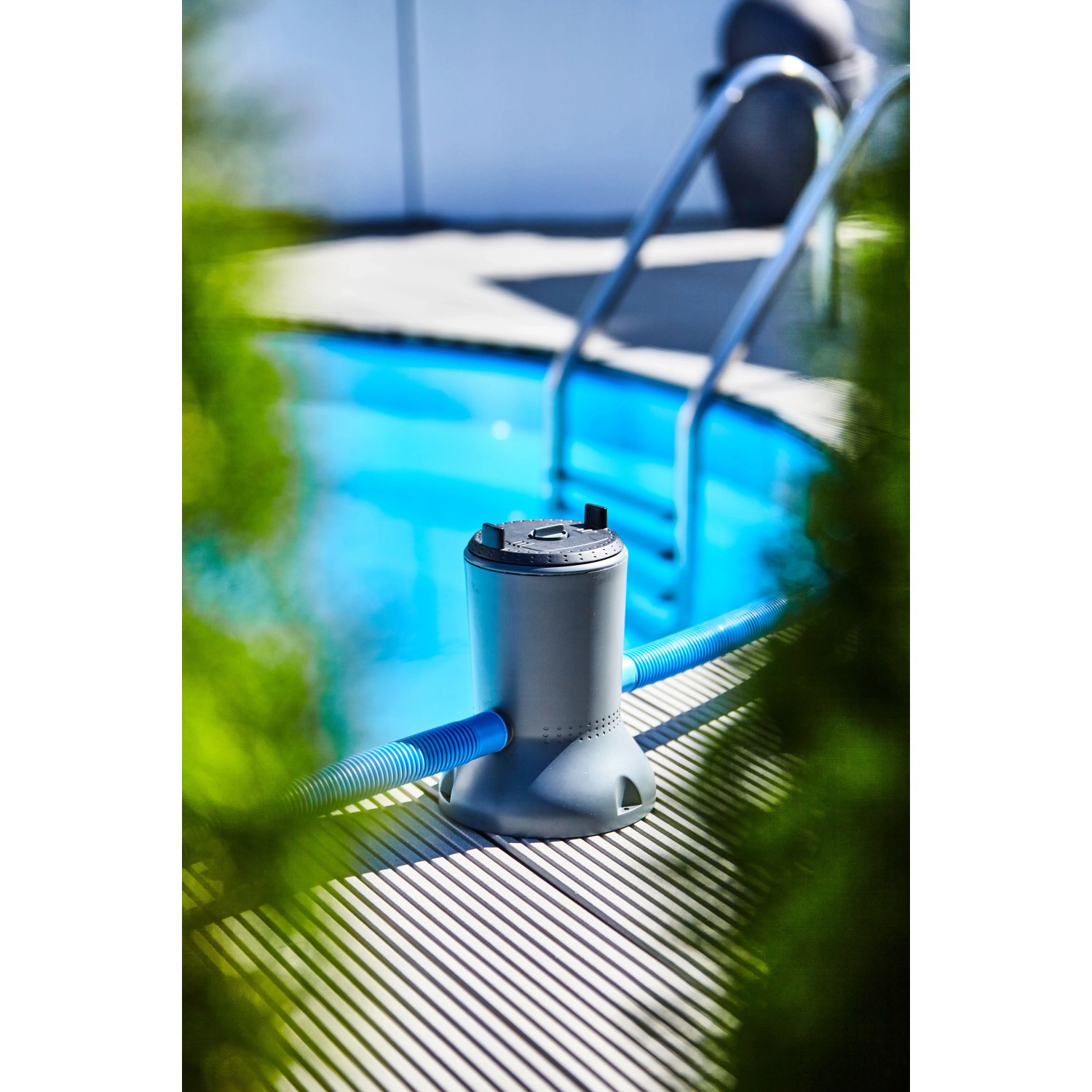 Summer Fun Solar-Pool-Kartuschenfilteranlage am Pool, graue Pumpe mit blauen Schläuchen.