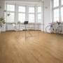 Verlegtes Kronoflooring Binyl Pro Laminat Major Oak im hellen Raum mit Möbeln.