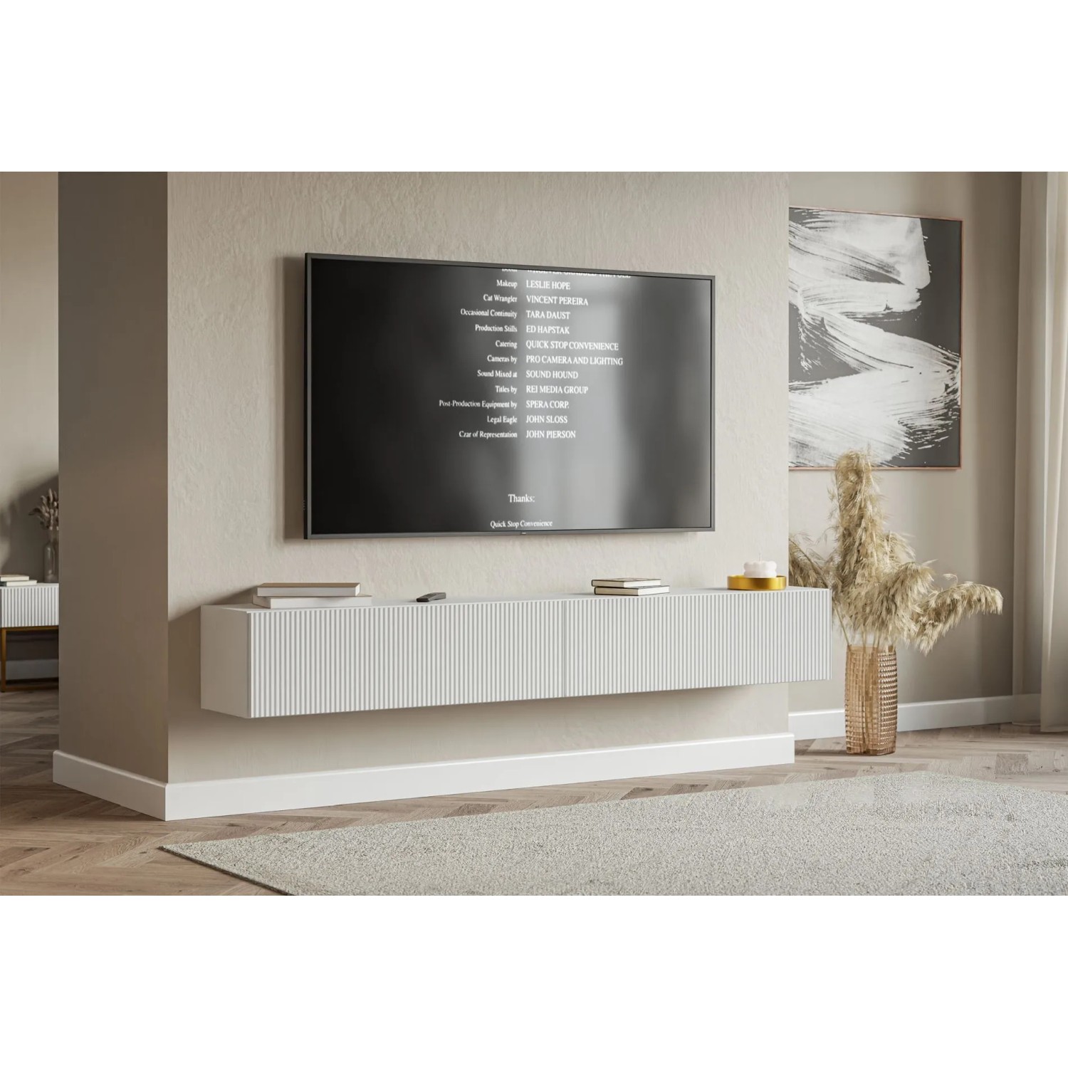 Modernes weißes Selsey Veldio TV-Hängeboard mit geriffelter Lamellenfront, schwebend unter einem Fernseher im Wohnzimmer.