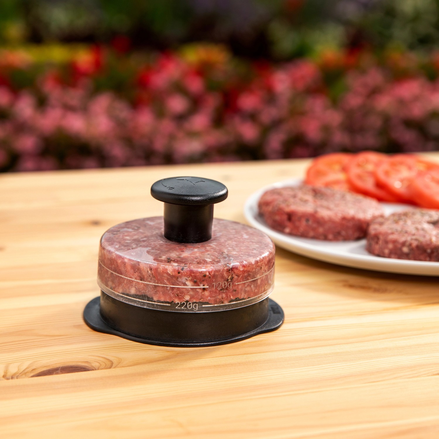 Weber Hamburgerpresse, schwarz/transparent, mit Hackfleisch gefüllt. Grillutensil für Burger.