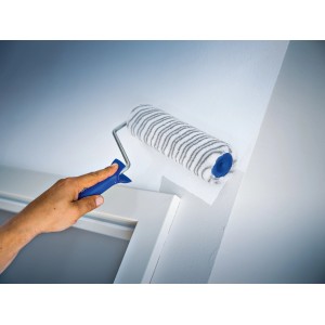 LUX Dispersionsroller 18cm beim Streichen einer Wand. Farbroller mit grau-gestreiftem Kurzflor und blauem Griff.