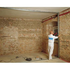 Ein Mann montiert ein Knauf CW-Profil (50x50) an einer Wand. Ständerwerk für den Innenausbau.