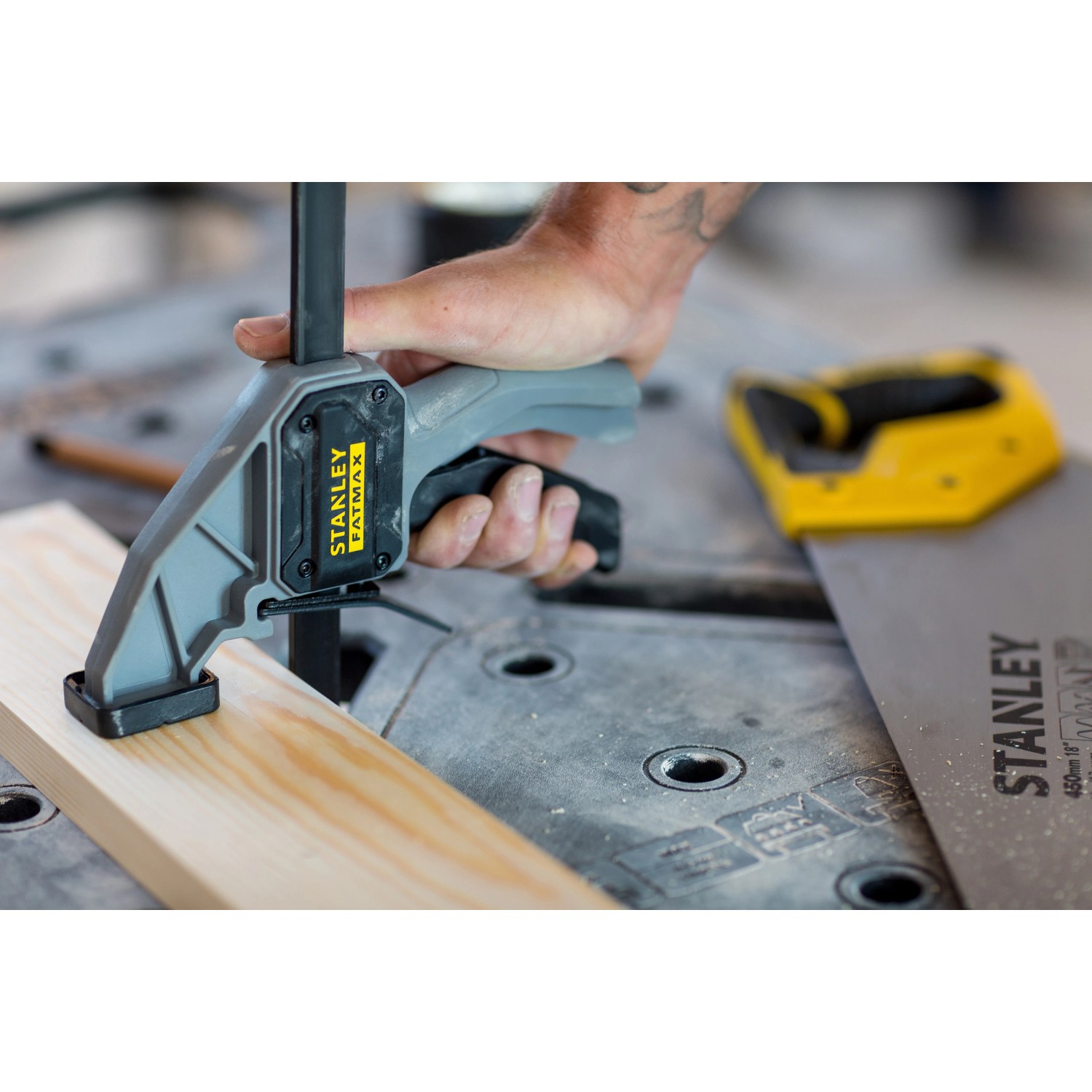 Stanley FatMax Werkbank: Hand fixiert Holzstück mit einer Schraubzwinge auf der Werkbank.