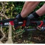 Skil Akku-Ästsäge 0512CA mit 15 cm Schwertlänge im Einsatz beim Schneiden von Ästen.