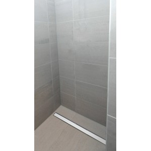 Edelstahl Duschrinne 90 cm in ebenerdiger Dusche mit grauen Fliesen.