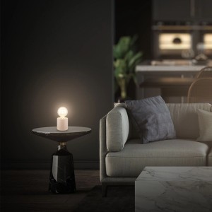 Beige Brilo Tischleuchte Tubo Keramik auf Tisch neben Sofa. Design-Tischlampe für Wohnraum.