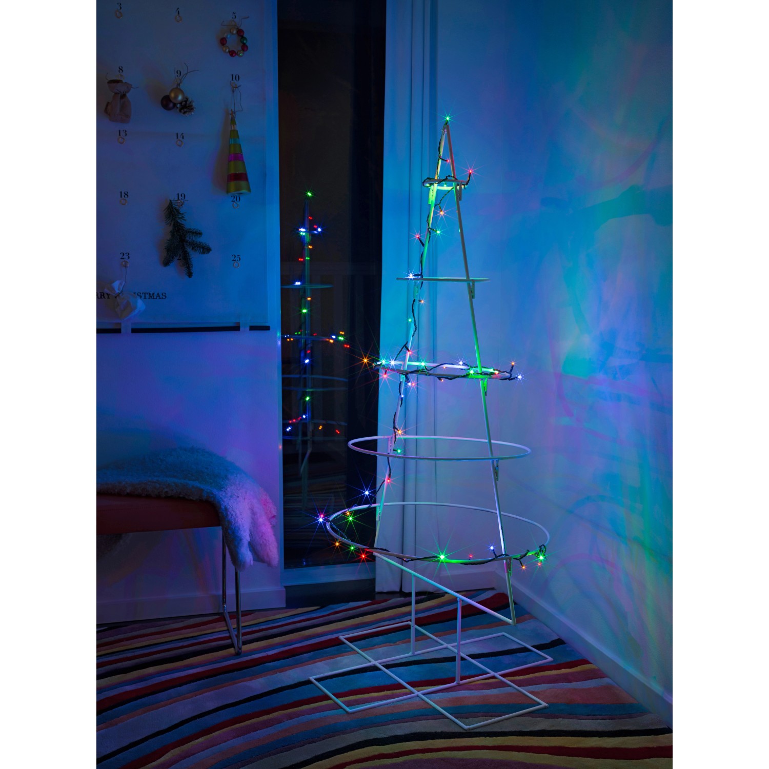 Konstsmide LED Micro Lichterkette mit 100 bunten Lichtern an einem Deko-Baum im Innenraum.