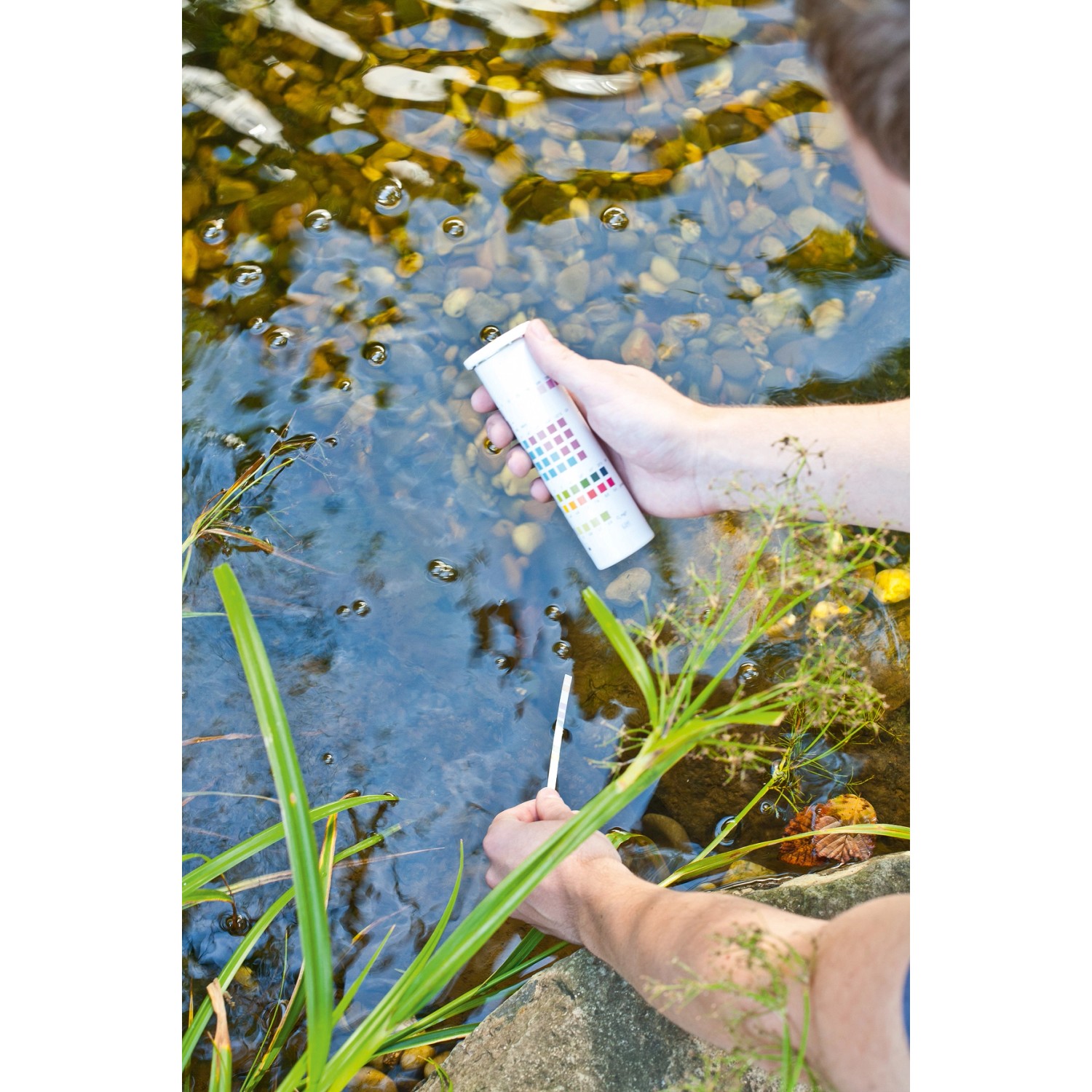 Mann testet Teichwasser mit Heissner Schnell-Test-Set 6in1 auf Wasserwerte.