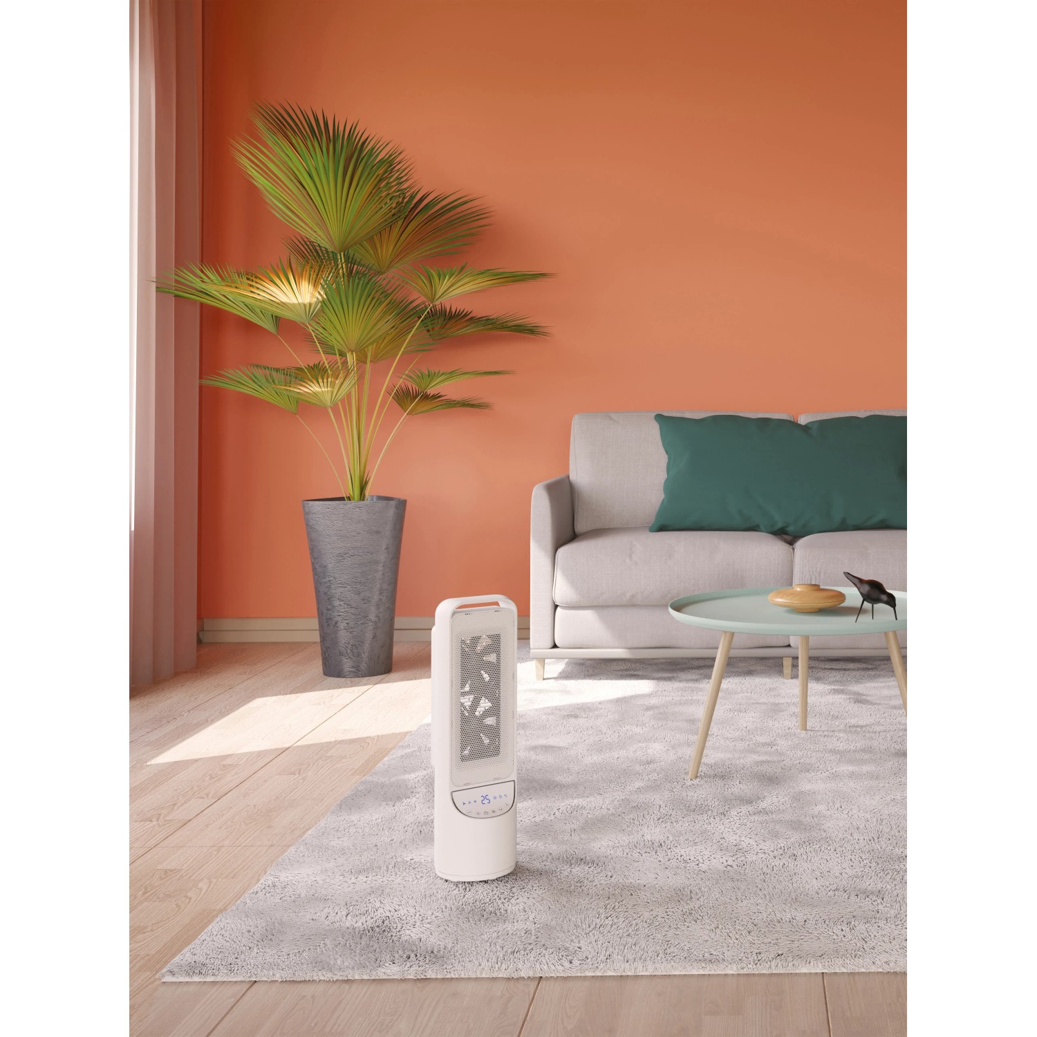 Weißer Keramik-Heizlüfter Nagu 2000 W im Wohnraum mit Sofa und Pflanze.