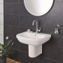 Grohe Euro Keramik Waschbecken, 65 cm, Alpinweiß mit Armatur und Spiegel vor dunkler Wand.